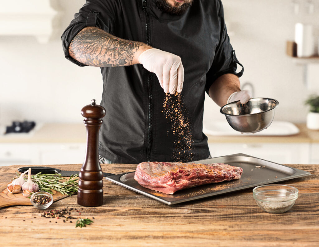 L'immagine di uno chef che condisce una bistecca, in un articolo sulle ricette fantasiose di carne.