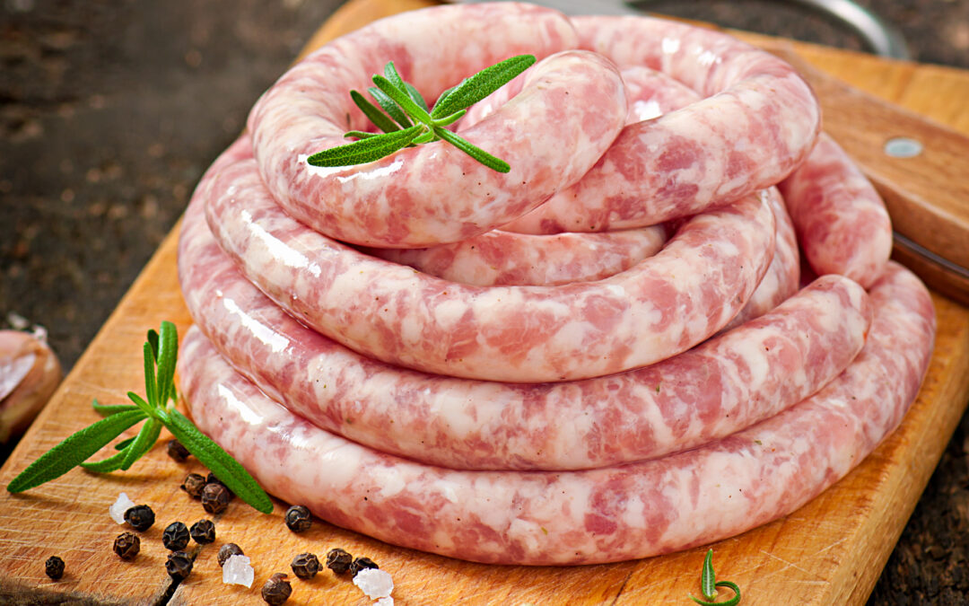 Come cucinare la salsiccia? Nell'immagine un involto di salsiccia cruda pronta per essere preparata.