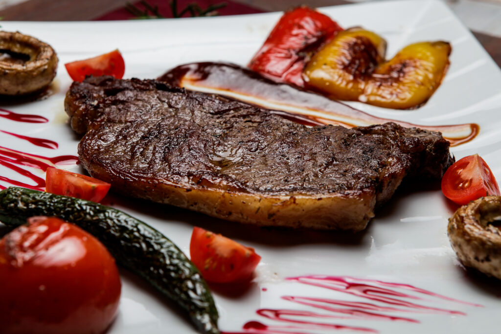 Difficile capire quale sia il grado di cottura migliore per la carne. Nella foto vediamo una bistecca mediamente cotta, con un contorno di verdure.