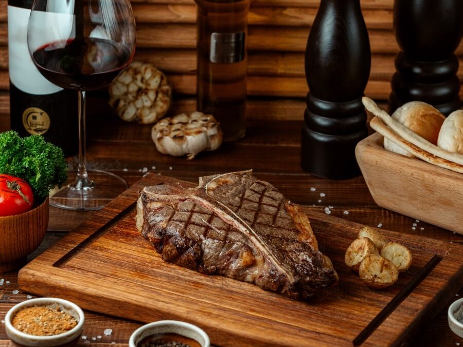 È possibile condire la carne con i superalcolici? Le possibilità, fra salse e marinature, sono tante, ma bisogna sapere bene cosa scegliere. In questa foto diversi piatti di carne circondati da bottiglie.