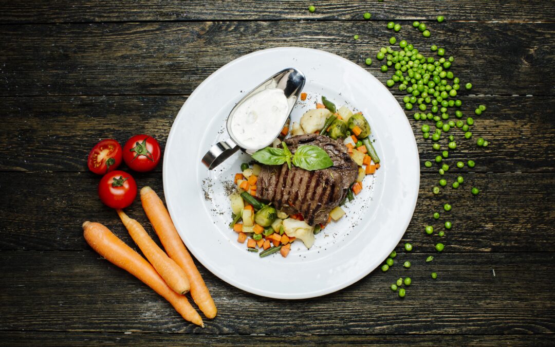 Carne è patate sono un connubio vincente; di questi tempi, però, vince però l'accoppiata carne con la verdura. In questa foto, un piatto di carne circondato da vari condimenti di verdura.