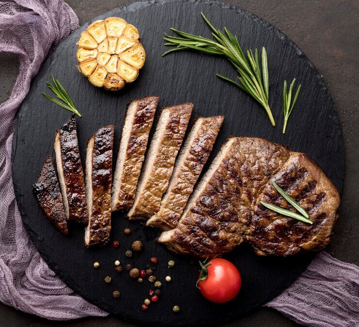 La picanha è un taglio di carne di origini brasiliane, diventato celebre in Italia. Nella foto, una picanha tagliata a fette su un tagliere di legno.