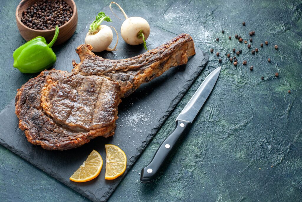 La foto di una bistecca di tomahawk servita a tavola. Uno dei più singolari piatti di carne.