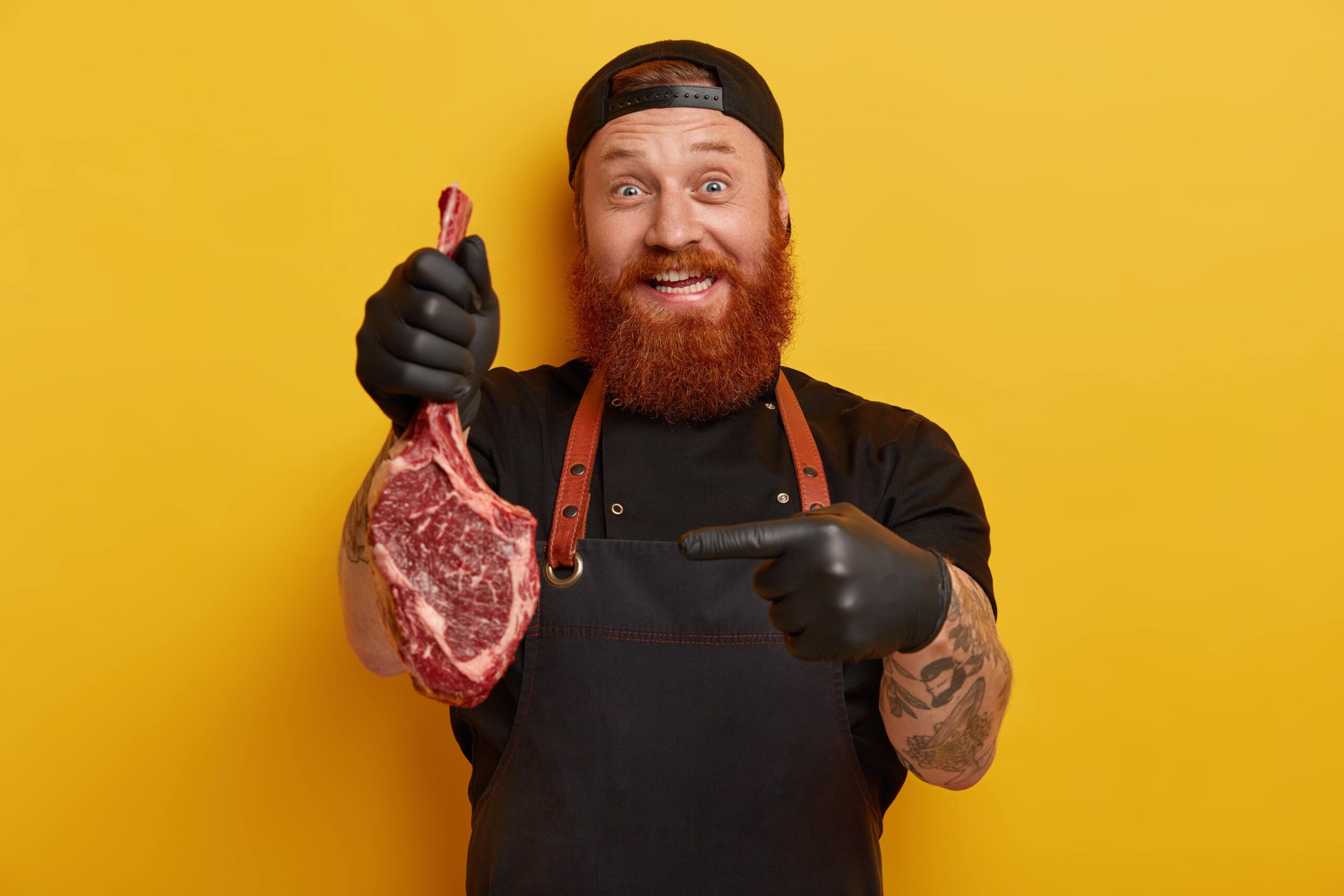 In casi di colesterolo alto è consigliato mangiare la carne? Le teorie sono tante, ma nessuna di esse propende per un'eliminazione totale di questo argomento. Nella foto, un uomo che indica una bistecca cruda.