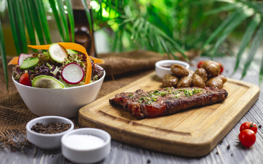 Come cucinare la carne in estate? Le soluzioni sono tante e comprendono sia carne da preparare fredda che ricette invernali che possono essere servite a temperatura ambiente. Nella foto, un piatto di carne gustato in uno scenario estivo.