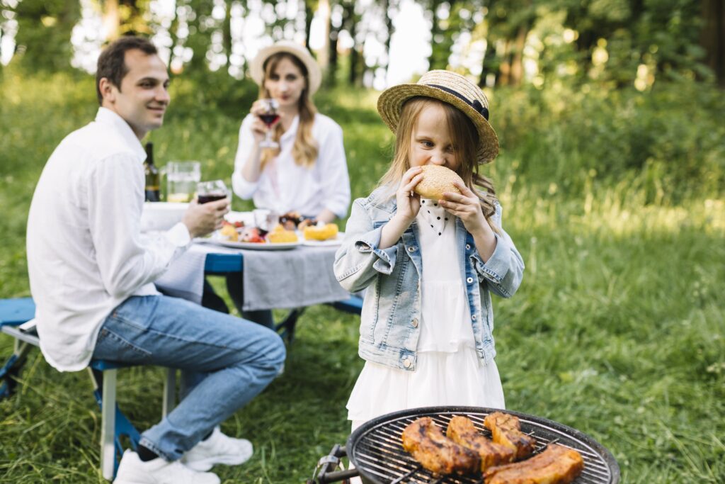 Come cucinare la carne in estate? Le soluzioni sono tante. Una grigliata in famiglia, però, vince sempre. Nella foto una famiglia che consuma carne durante un picnic.