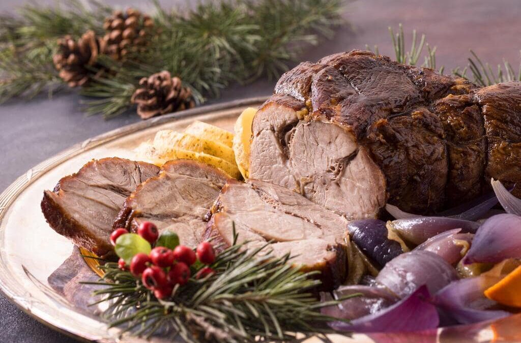 La carne, nel periodo natalizio, è protagonista indiscusso delle nostre tavole. Ma come orientarsi con i tagli di carne a Natale? Nella foto, della carne arrosto su una tavola natalizia.
