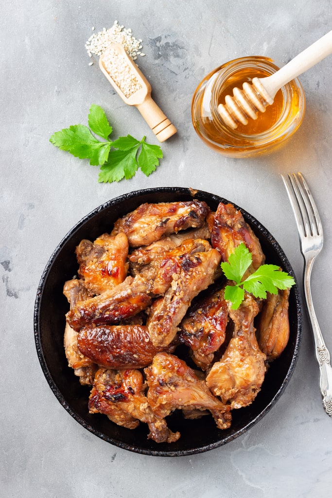 Un tempo si pensava che il miele nelle ricette di carne fosse una moda del momento o il capriccio di qualche chef bramoso di sperimentare. Oggi, però, è diventato un ingrediente di successo per insaporire la carne nei modi più deliziosi. Nella foto del pollo con del miele vicino.