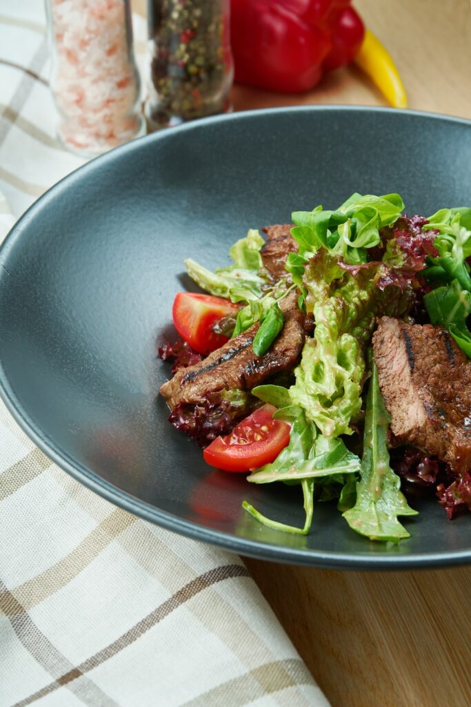 Gli straccetti di manzo con rucola e pomodorini -mostrati nella foto- sono fra i piatti legger di carne più apprezzati.